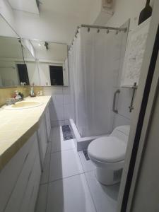 a white bathroom with a toilet and a shower at Wilson's Home in Lima