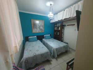 two beds in a room with blue walls at Wilson's Home in Lima