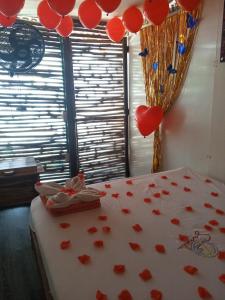 um quarto com corações vermelhos e balões numa cama em Venido del mar III em Playa Blanca