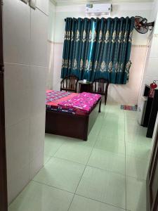 a room with a bed and chairs and a curtain at Khách Sạn Giang Phước Hùng in Ho Chi Minh City
