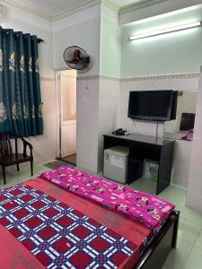 a living room with a bed and a television at Khách Sạn Giang Phước Hùng in Ho Chi Minh City
