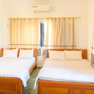 - 2 lits dans une chambre avec des rideaux dans l'établissement Cẩm Hương Motel, à Hanoï