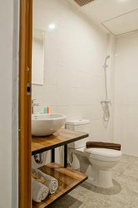 a white bathroom with a sink and a toilet at Jember Town Square by Calli Rooms in Wirolegi +44 photos