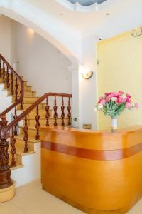 un escalier avec un vase de fleurs roses dans l'établissement Cẩm Hương Motel, à Hanoï