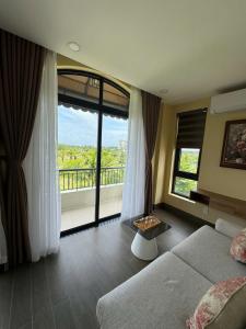 a living room with a couch and a large window at The Costis Home in Phu Quoc