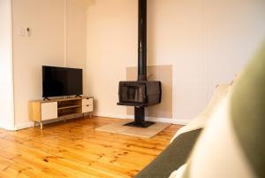a living room with a television and a fireplace at Coastal Escape 3BR 2BA Family Retreat in Sellicks Beach