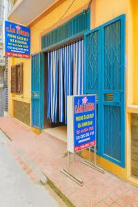 un panneau devant un bâtiment avec des portes bleues dans l'établissement Cẩm Hương Motel, à Hanoï