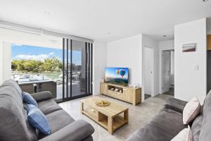 a living room with a couch and a tv at Marina Retreat in Sandstone Point