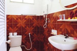 un baño con inodoro y lavabo en Samma Karuna Beach & Wellness Resort - Intoxicants free, en Srithanu