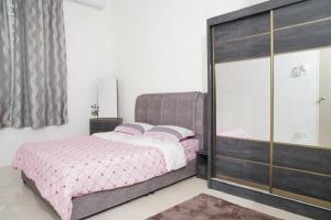 a bedroom with a pink bed and a large glass closet at Berkat Juta Homestay 2 in Kuantan