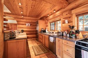a large kitchen with wooden walls and wooden cabinets at Heron Chalet by Outpost Whistler in Whistler +64 photos