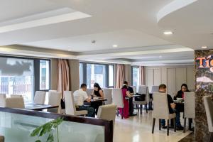 a group of people sitting at tables in a restaurant at Ciao SaiGon Hotel & Spa in Ho Chi Minh City