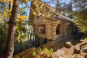 a log cabin in the woods with a tree at Heron Chalet by Outpost Whistler in Whistler