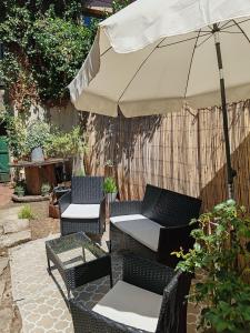 a patio with two chairs and an umbrella at Appartement cosy 70 m2 tout confort 4 personnes in Ainay-le-Château +11 photos