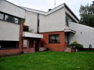 a house with a grass yard in front of it at Pokoje Gościnne pod Sikornikiem in Kraków