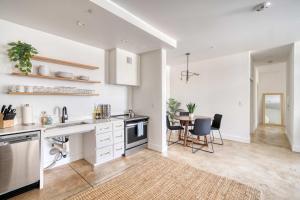 a kitchen with white cabinets and a table with chairs at Studio Bliss Dual-Queen Stay in Vibrant Alberta in Portland