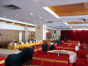 a dining room with tables and red chairs at Shanshui Hotel in Xiamen