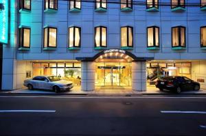 two cars parked in front of a building at night at Oita Century Hotel in Oita