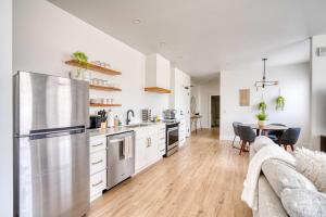a kitchen with a stainless steel refrigerator and a table at Stay Portland - City Serenity- Stylish 2-Bed Alberta Haven in Portland +32 photos