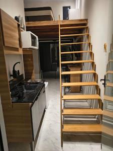 a staircase leading up to a loft bed in a kitchen at Loft aconchegante in Ilhota