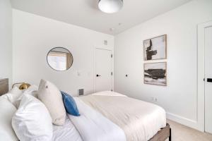 a white bedroom with a bed and a mirror at Stay Portland - Stylish Luxe Suite N Williams & Alberta Districts in Portland