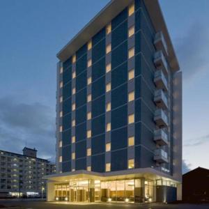 a large blue building with windows in a city at a.Suehiro Hotel in Oita