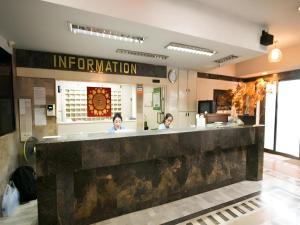 two women sitting at a counter in a restaurant at Numsin Hotel in Ban Rong Chang