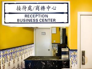 a sign for a reception of a business center at Happy Family Hotel in Macau