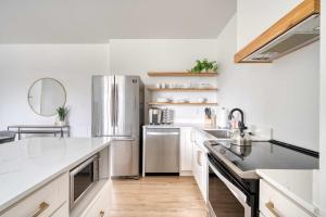 eine Küche mit weißen Schränken und einem Edelstahlkühlschrank in der Unterkunft Stay Portland - The Cascadia Retreat - Luxury Home - 90 WalkScore in Portland + 27 Fotos