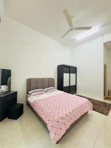 a bedroom with a pink bed with a ceiling fan at Berkat Juta Homestay 2 in Kuantan