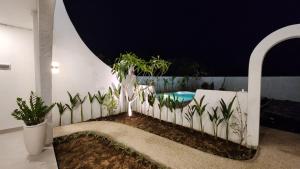 a fence with plants and a swimming pool at Bnaya Villas Riverside in Amed