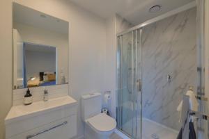 Un baño con ducha, inodoro y lavabo. en Cityside Comfort Modern 2BR 2BA with Parking, en Christchurch