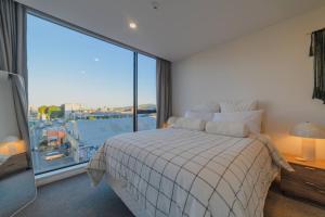 Un dormitorio con una cama y una ventana grande. en Cityside Comfort Modern 2BR 2BA with Parking, en Christchurch