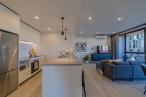 Una cocina y una sala de estar con un sofá azul. en Cityside Comfort Modern 2BR 2BA with Parking, en Christchurch