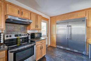 a kitchen with a stainless steel refrigerator and wooden cabinets at Alberta Arts Luxury Sleeps 4 Walk Score 99 in Portland