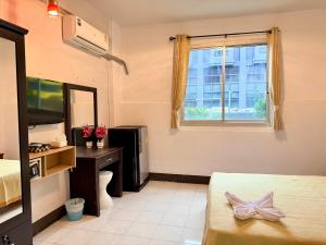 ein Hotelzimmer mit einem Bett und einem Fenster in der Unterkunft Om Sab House Patong in Patong Beach
