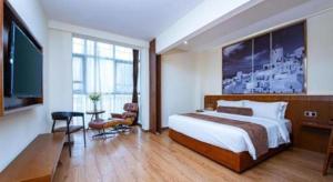 a bedroom with a large bed and a television at James Joyce Coffetel Wuhan Huanlegu Renhe Road Subway Station in Wuhan +18 photos