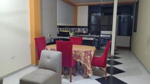 une cuisine avec une table et des chaises rouges dans l'établissement Hospedaje Luciana, à Pucallpa 26 autres photos