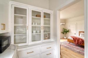 a white cabinet with glass doors in a bedroom at Stay Portland - The Sullivan's Gulch Lodge - 94 WalkScore in Portland