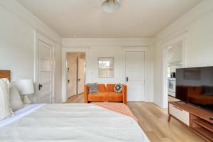 a bedroom with a bed and a couch and a television at Stay Portland - The Sullivan's Gulch Retreat - 94 Walk Score in Portland