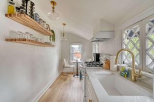 a white kitchen with a sink and a window at Stay Portland - The Sullivan's Gulch Retreat - 94 Walk Score in Portland +6 photos