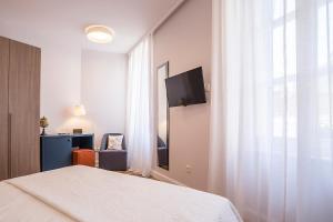 Televízia a/alebo spoločenská miestnosť v ubytovaní Piano Nobile Rooms