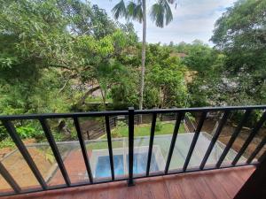 Un balcón con vista a la piscina y a los árboles. en Cinnamon Edge Mirissa, en Mirissa