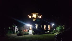 a house lit up at night with lights at Roomstay "Ghumah Uwan" bilik kayu in Batu Kikir
