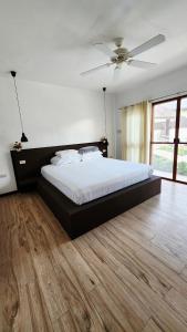 a bedroom with a large bed with a ceiling fan at Panglao Ramyer Villa 2 in Sampong +111 photos