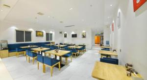 a dining room with tables and blue chairs at PAI Hotel·Luoyang Dingding Bei Road Hongjin Logistics International Peony Garden in Luoyang