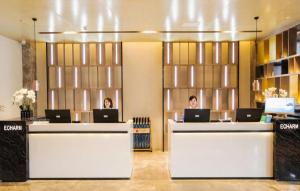 two people sitting at a counter with their laptops at Echarm Hotel Jingjiang Bus Passenger Station Fanggu Street in Jingjiang