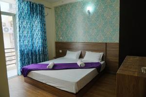 LāndrānにあるSparsha luxury- HomeStayのベッドルーム1室(紫のシーツが敷かれたベッド1台、窓付)