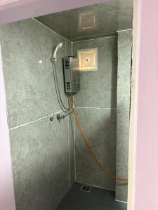 a shower with an orange cord attached to a wall at Highcamp B&B in Namche