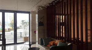 a living room with a couch and a large window at City Comfort Inn Hefei Railway Station Metro Station in Hefei